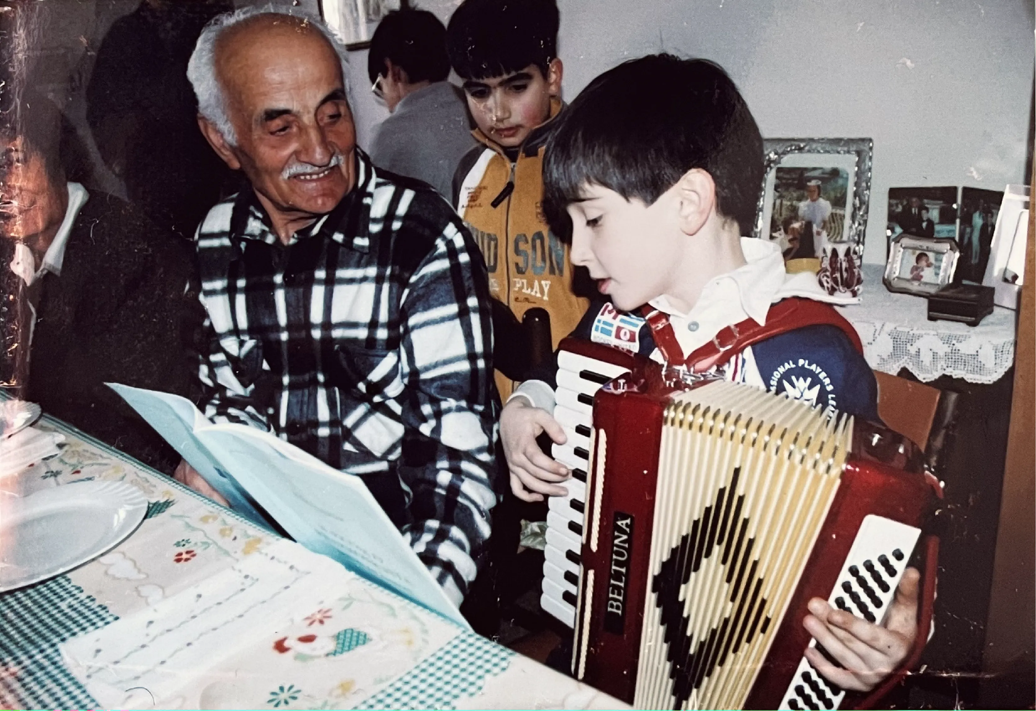 Young Carlo holding an accordion